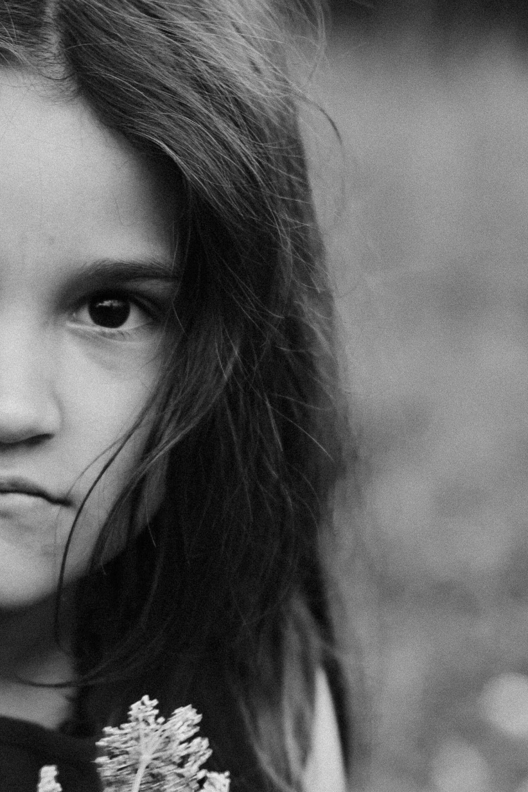 Rodzinna sesja fotograficzna w plenerze – rodzice z małym dzieckiem na łące, naturalne i ciepłe ujęcia.